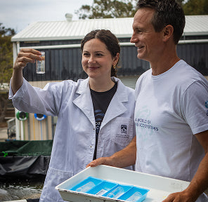 Marine scientists in lab coats testing water quality for aquarium design